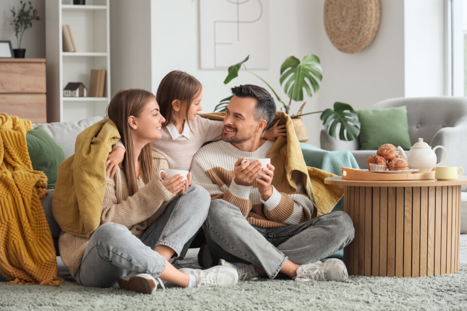 Little,Girl,Hugging,Her,Parents,With,Warm,Plaid,And,Cups